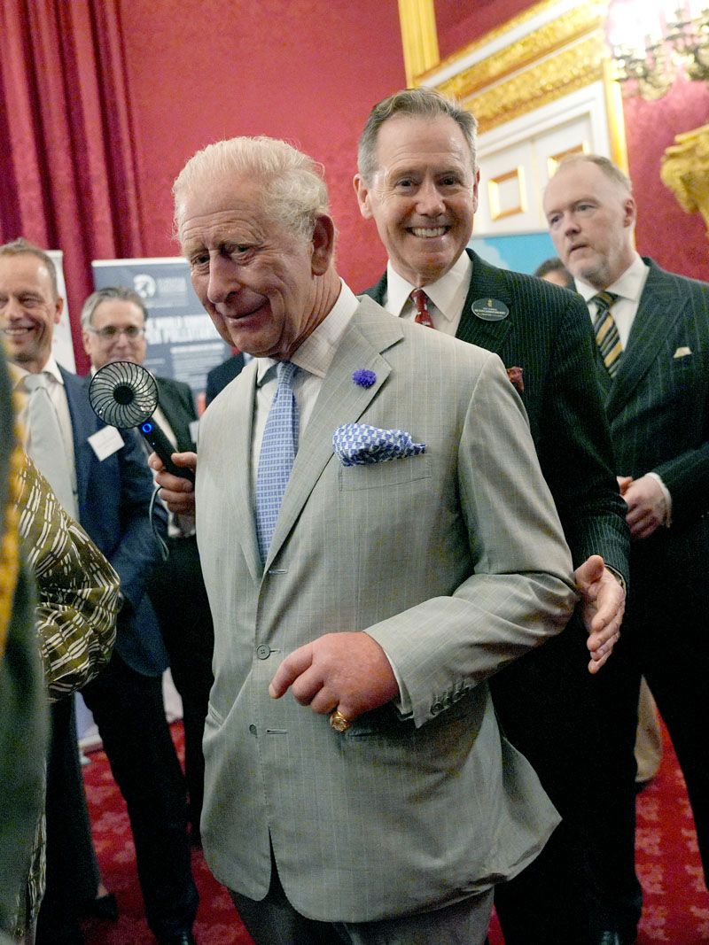 King Charles of England suffers from the heat... at the climate conference at St James's Palace in London! He dries himself several times with his handkerchief and someone holds a fane in front of his face (Gettyimages)