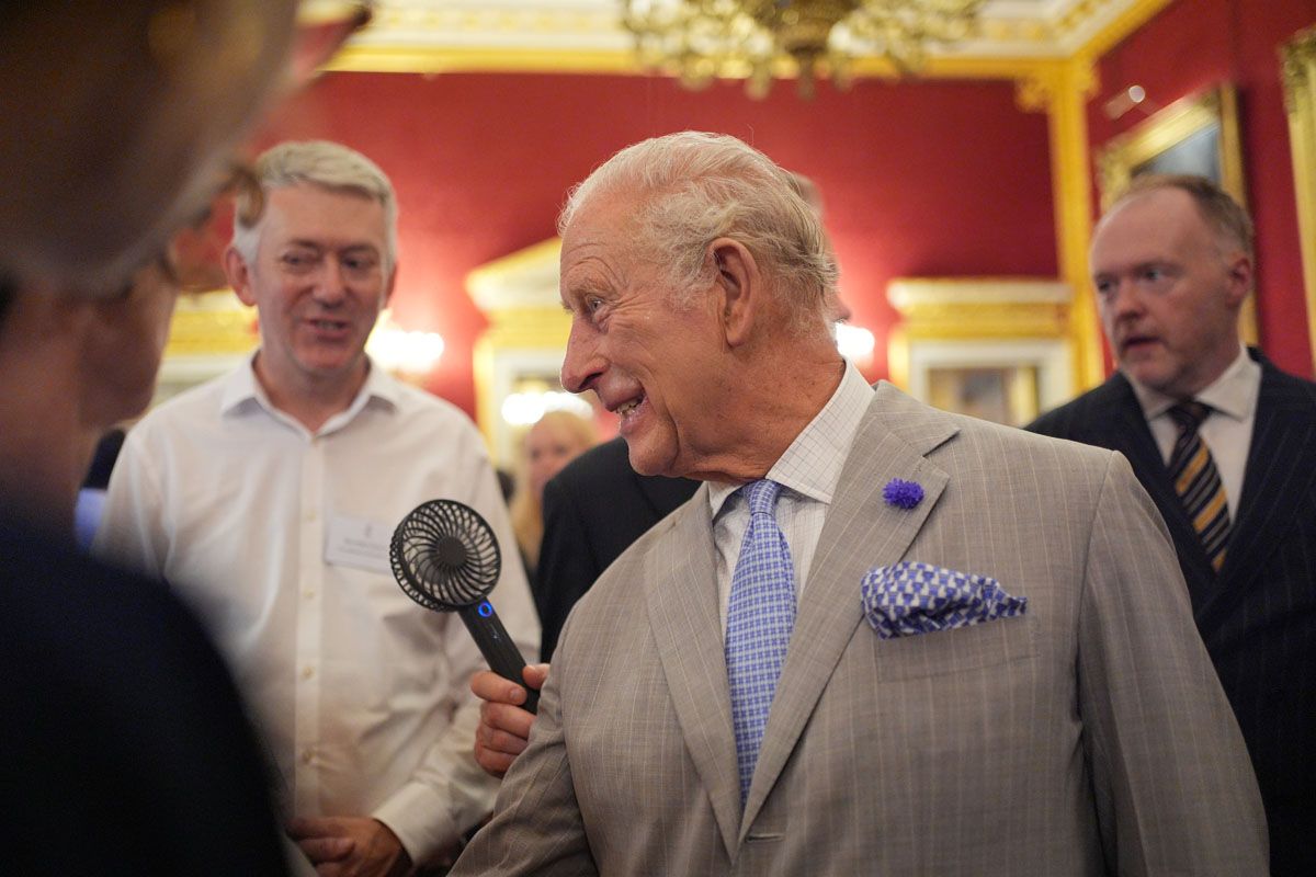 King Charles of England suffers from the heat... at the climate conference at St James's Palace in London! He dries himself several times with his handkerchief and someone holds a fane in front of his face (Gettyimages)