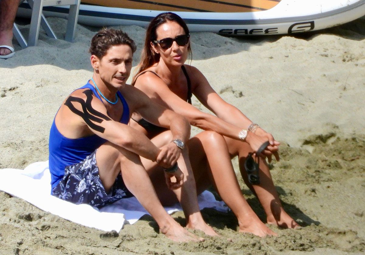 Pier Silvio Berlusconi and Silvia Toffanin sulla spiaggia di Portofino dopo l'incidente stradale che ha coinvolto, in particolare - come si può vedere - la spalla destra (da ufficio stampa Mediaset)