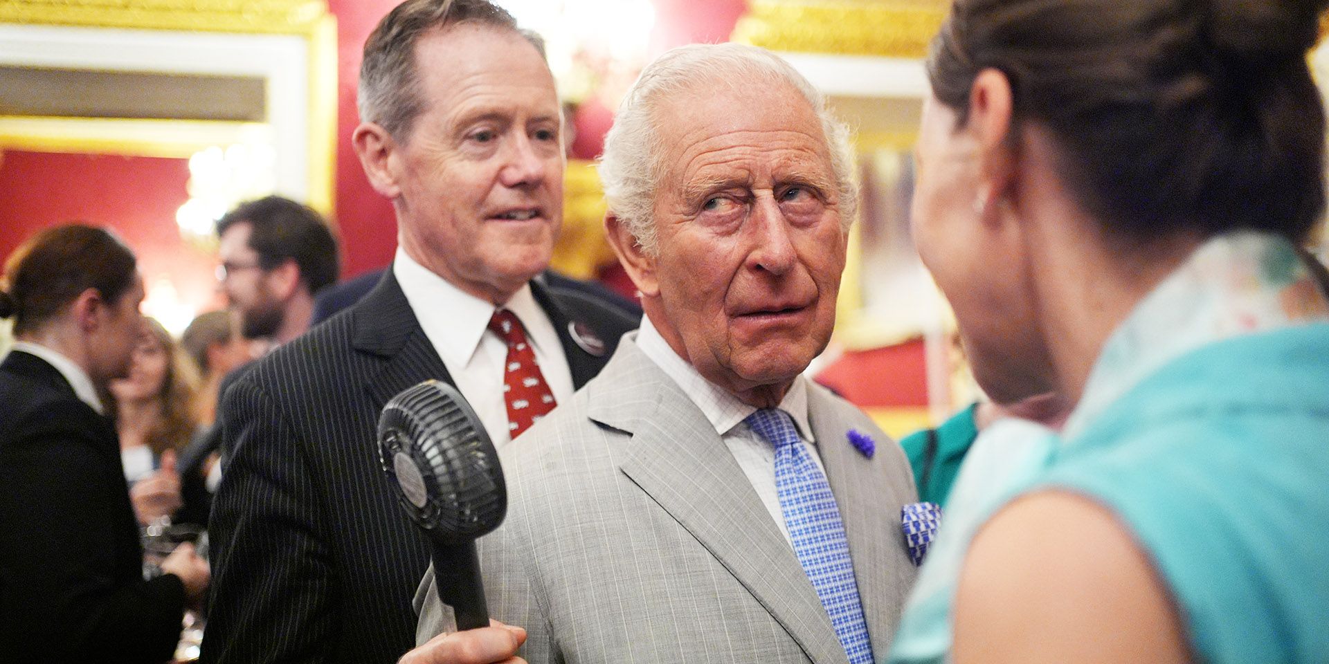 King Charles of England suffers from the heat... at the climate conference at St James's Palace in London! He dries himself several times with his handkerchief and someone holds a fane in front of his face (Gettyimages)
